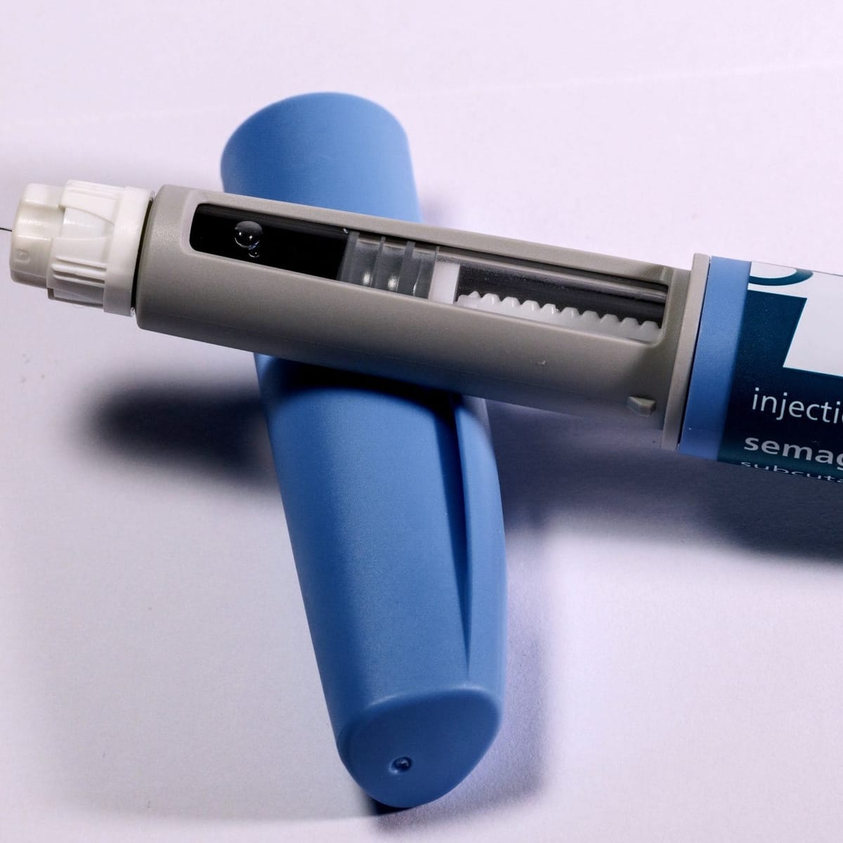 Close up image of an autoinjector device on top of its safety c