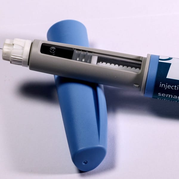 Close up image of an autoinjector device on top of its safety c